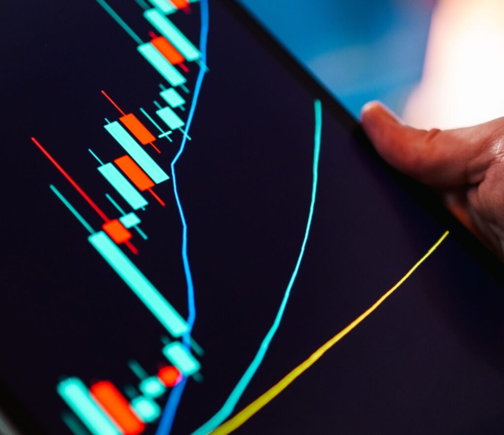 A close-up of a tablet displaying a colorful candlestick chart, ideal for finance and technology themes.