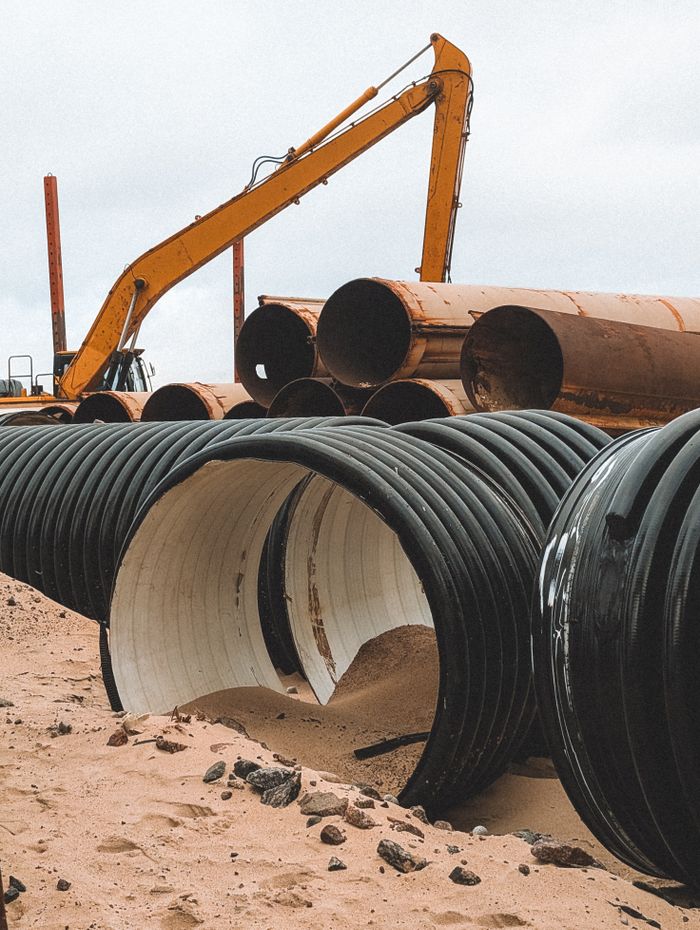 Large industrial pipes and machinery at a construction site in Svetlogorsk, Russia.